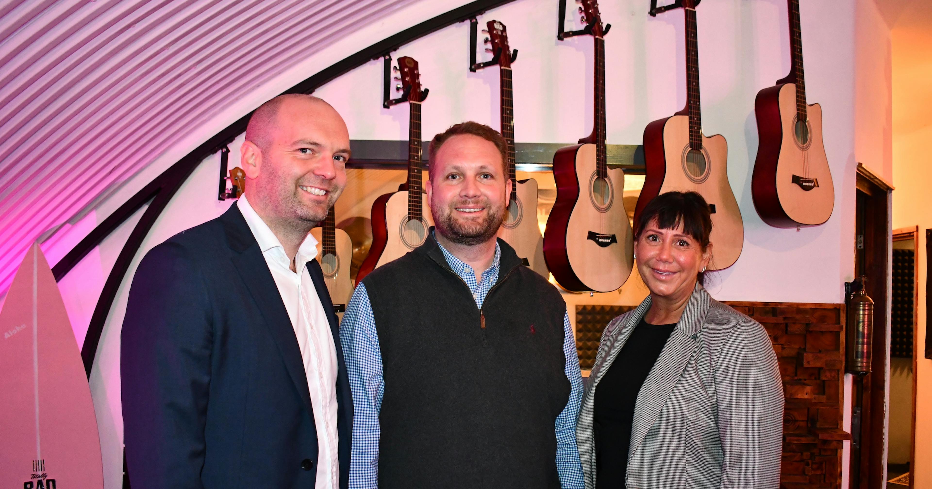 Team in front of guitars in studio