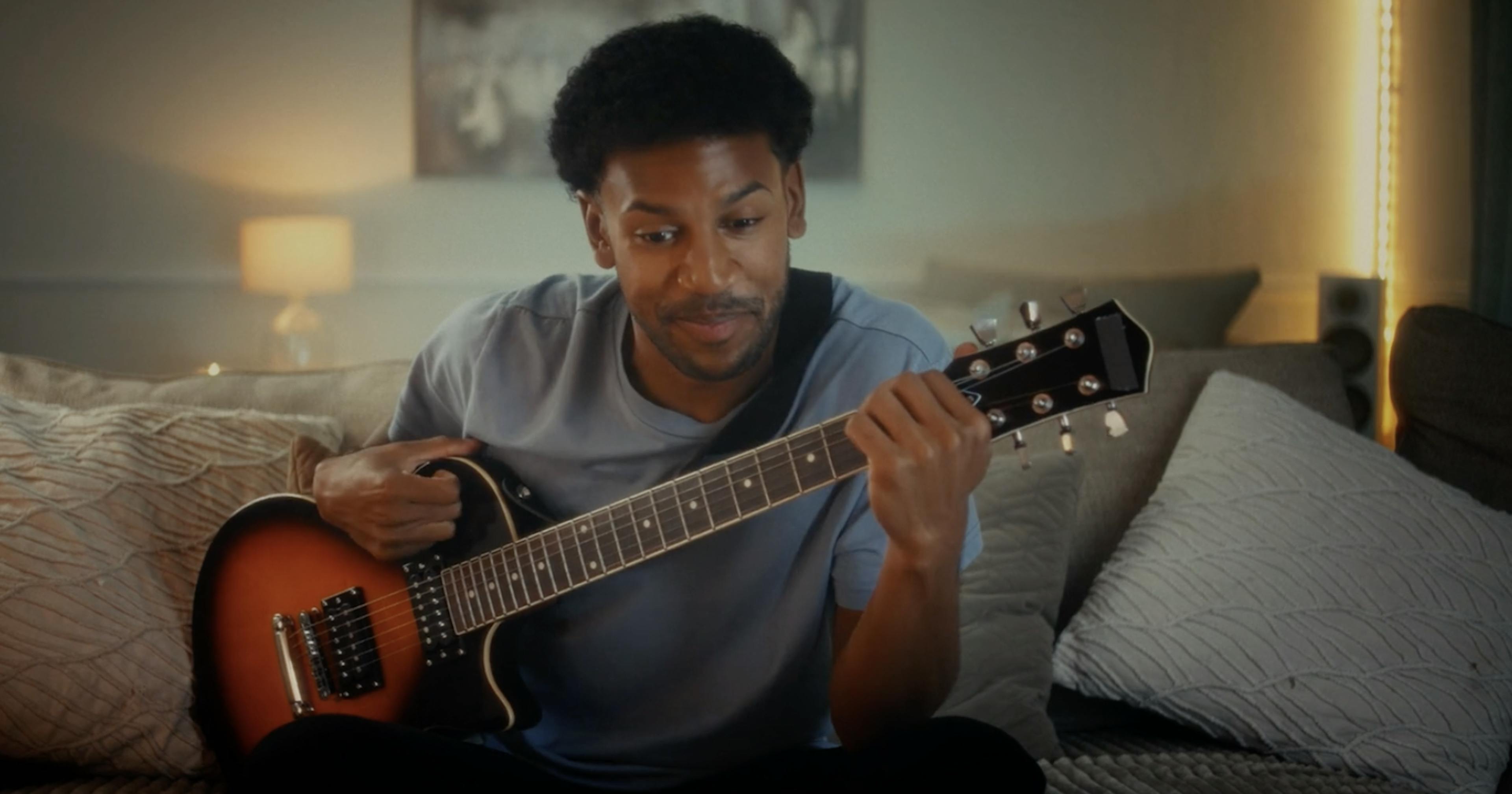 Man holding guitar in living room