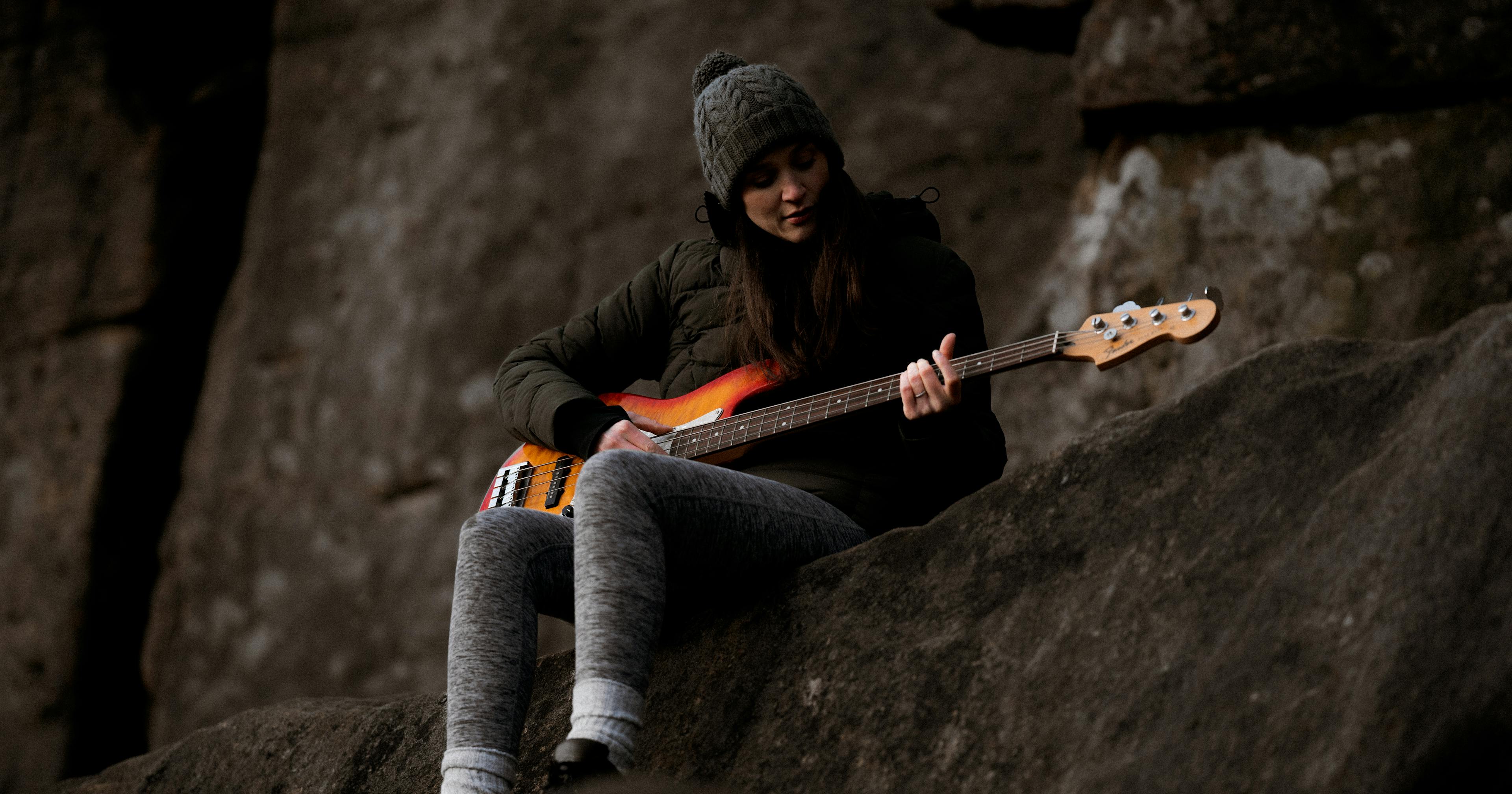 girl playing base on side of mountain