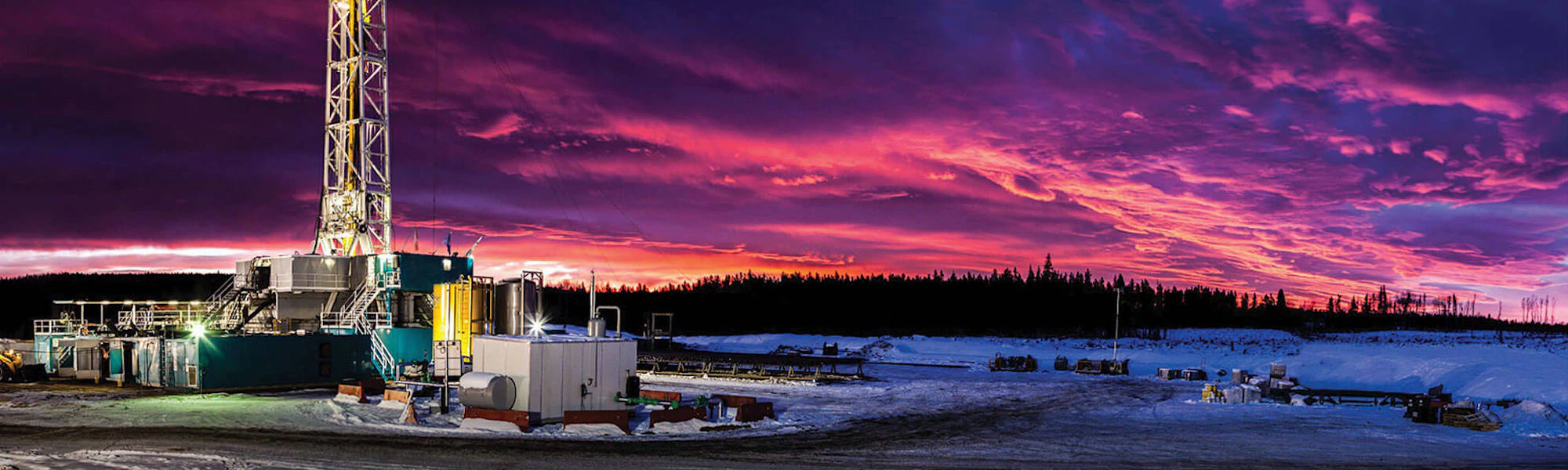 A rig tower with purple and blue storm clouds in the distance.