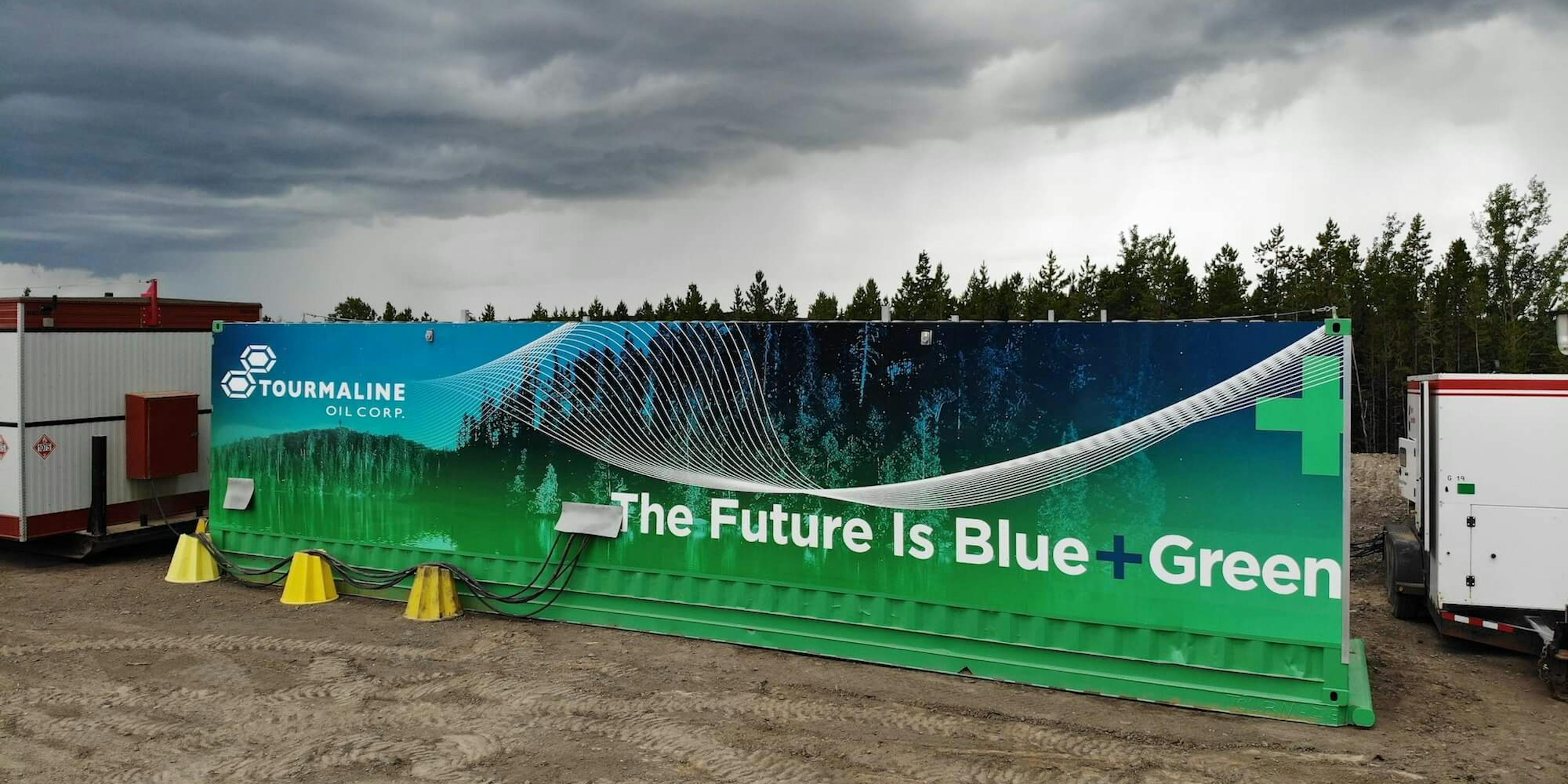 A large sign reading 'Tourmaline Oil Corp: The Future is Blue + Green' with stormclouds in the background.