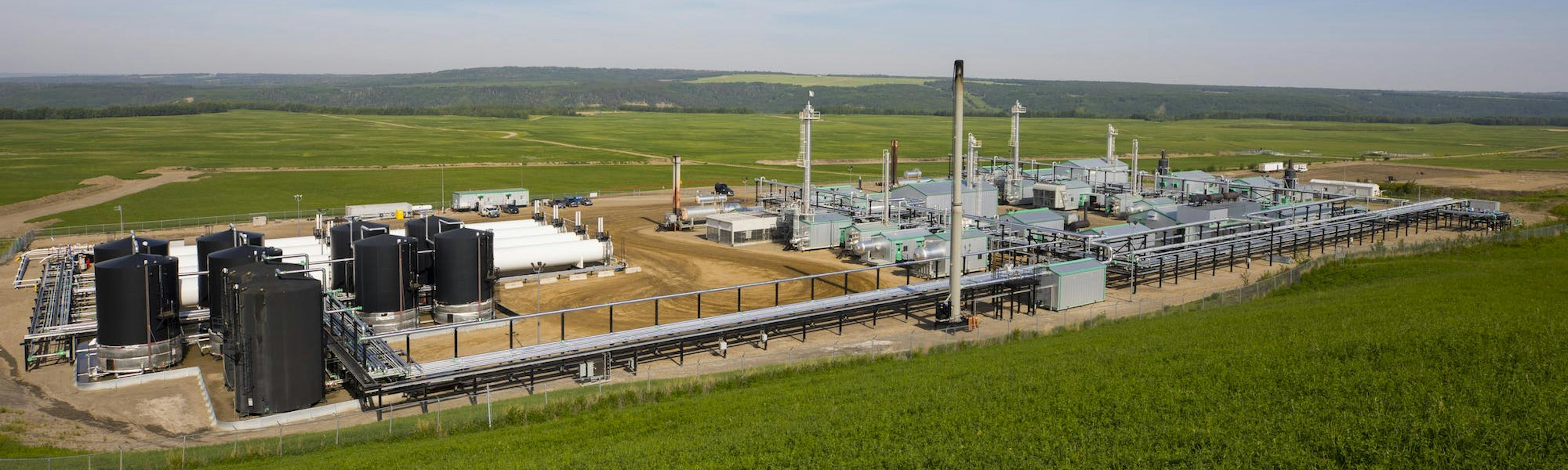 A wide view of a gas plant in a green field.