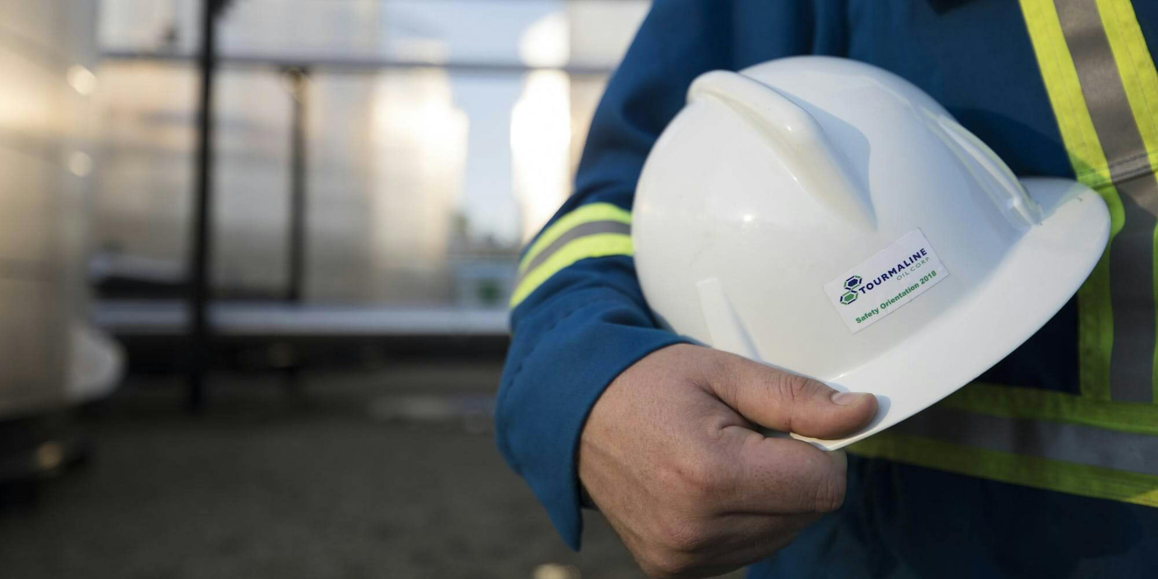 A worker named Peter displays his Tourmaline Oil Corp hard hat.