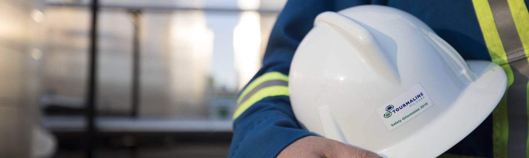 A worker named Peter displays his Tourmaline Oil Corp hard hat.