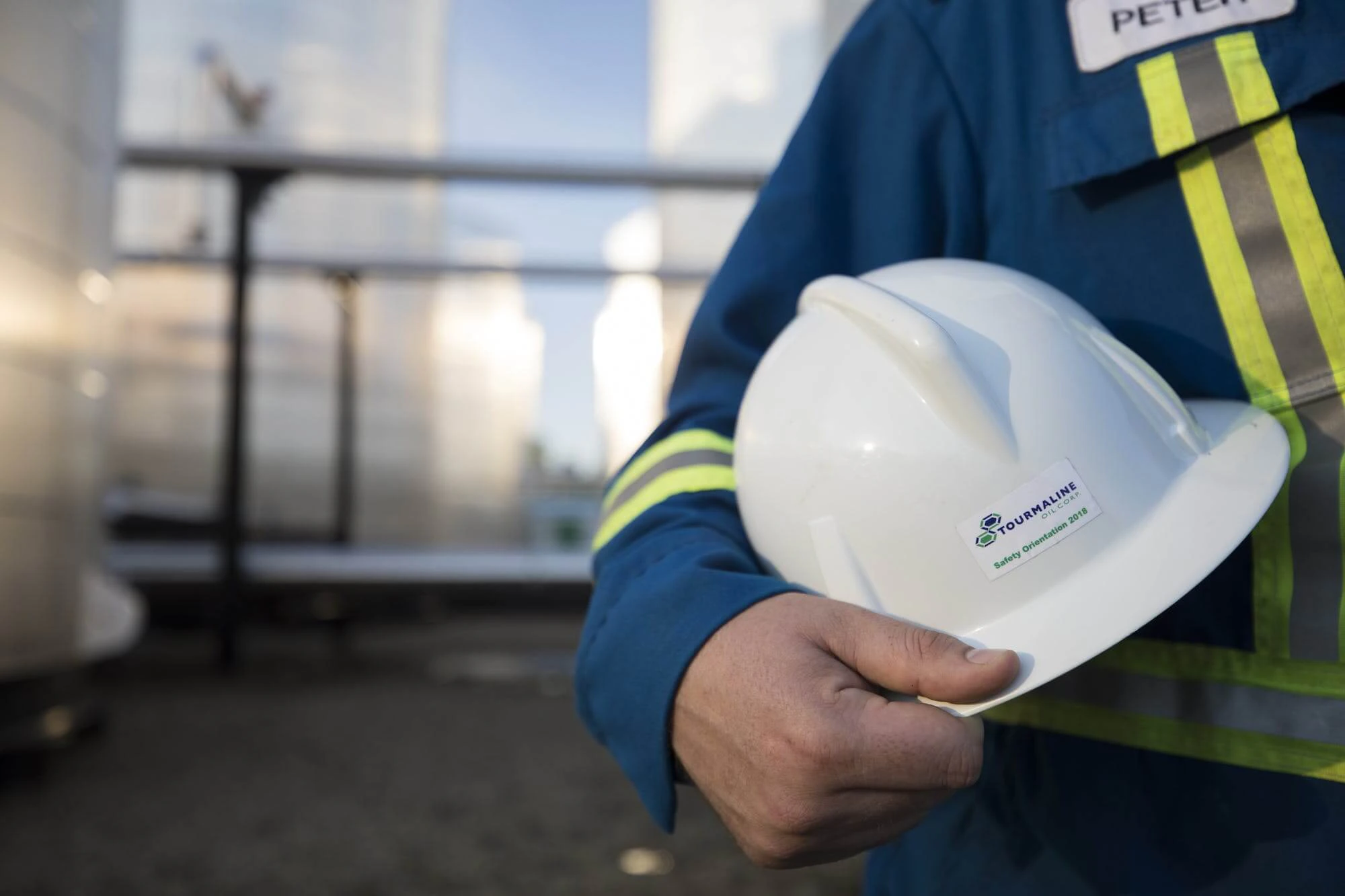 A worker named Peter displays his Tourmaline Oil Corp hard hat.