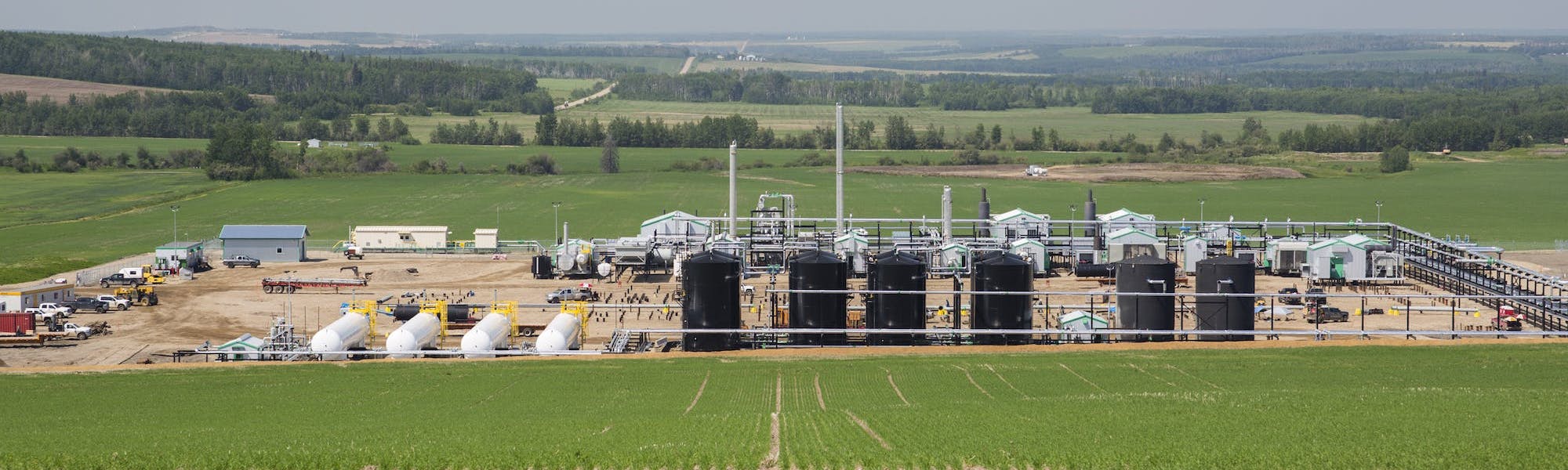 A wide view of a gas plant in a green field.