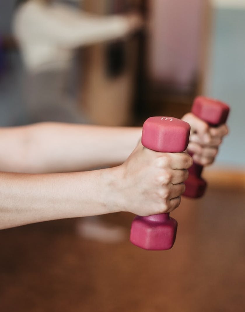 Two outstretched arms holding weights