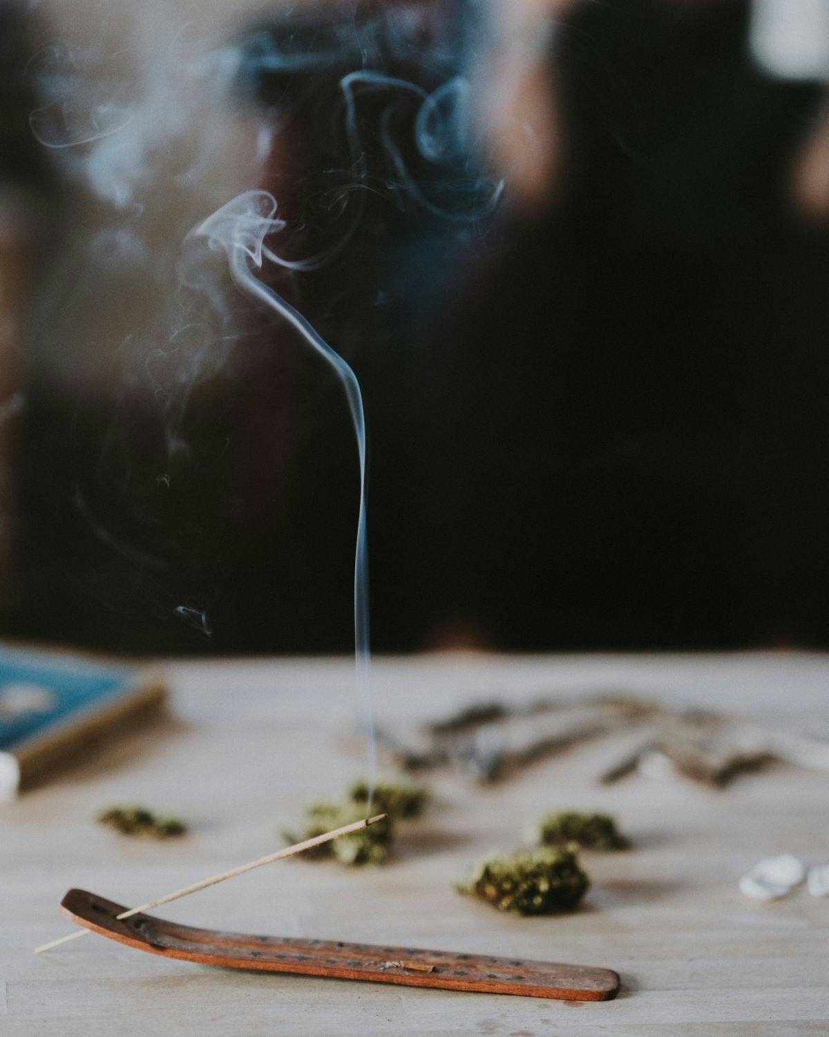 Incense burning with flower in the background