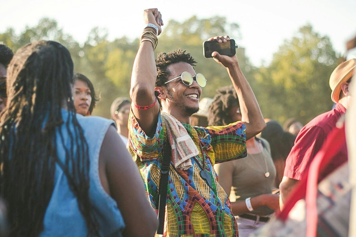 Man in the crowd at a concert dancing with his arms in the air