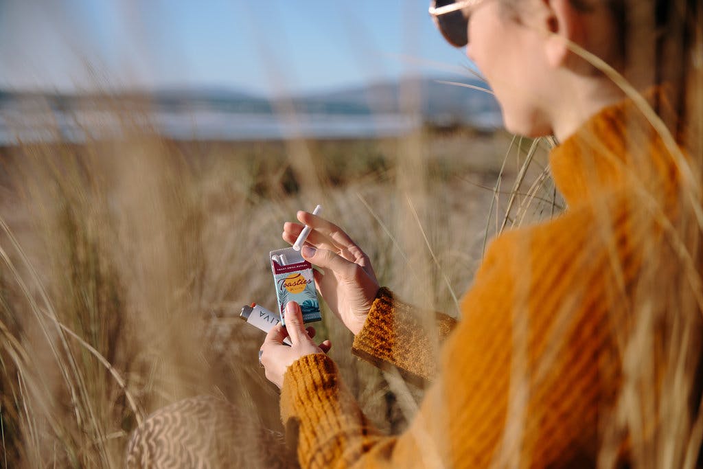 Woman holding Caliva Toasties, low-dose pre-rolls