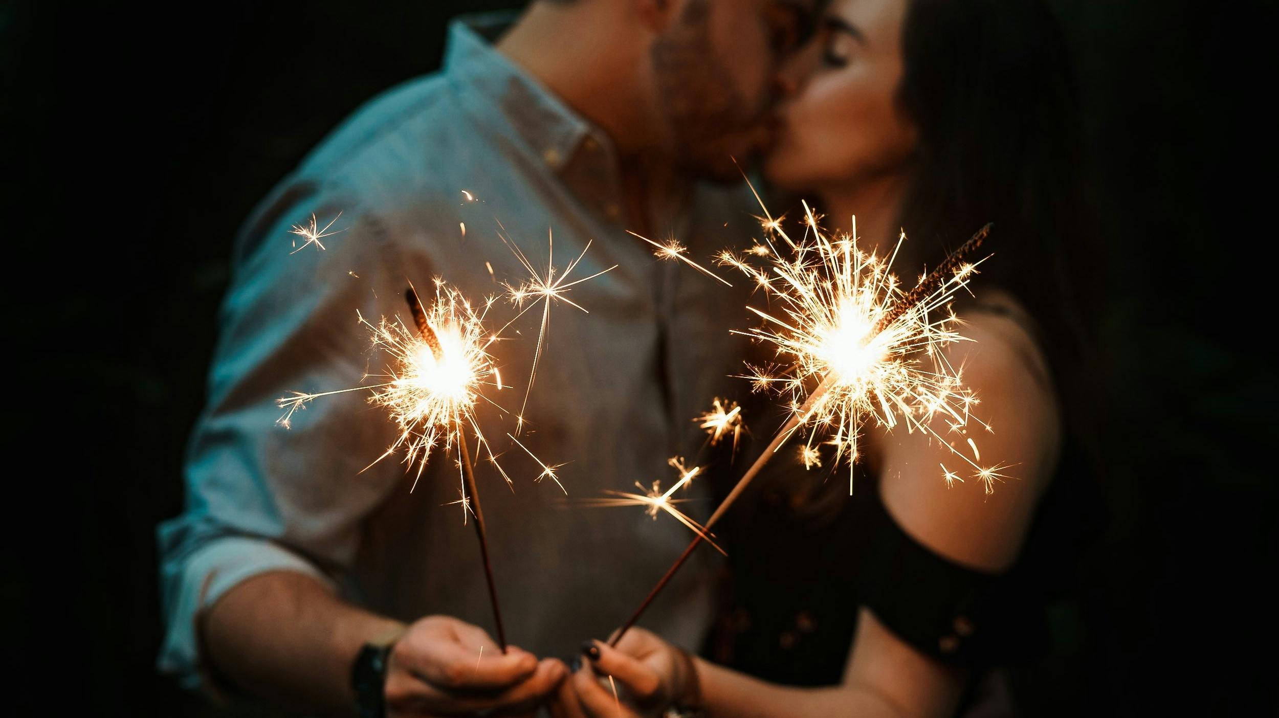 Couple kissing with fireworks