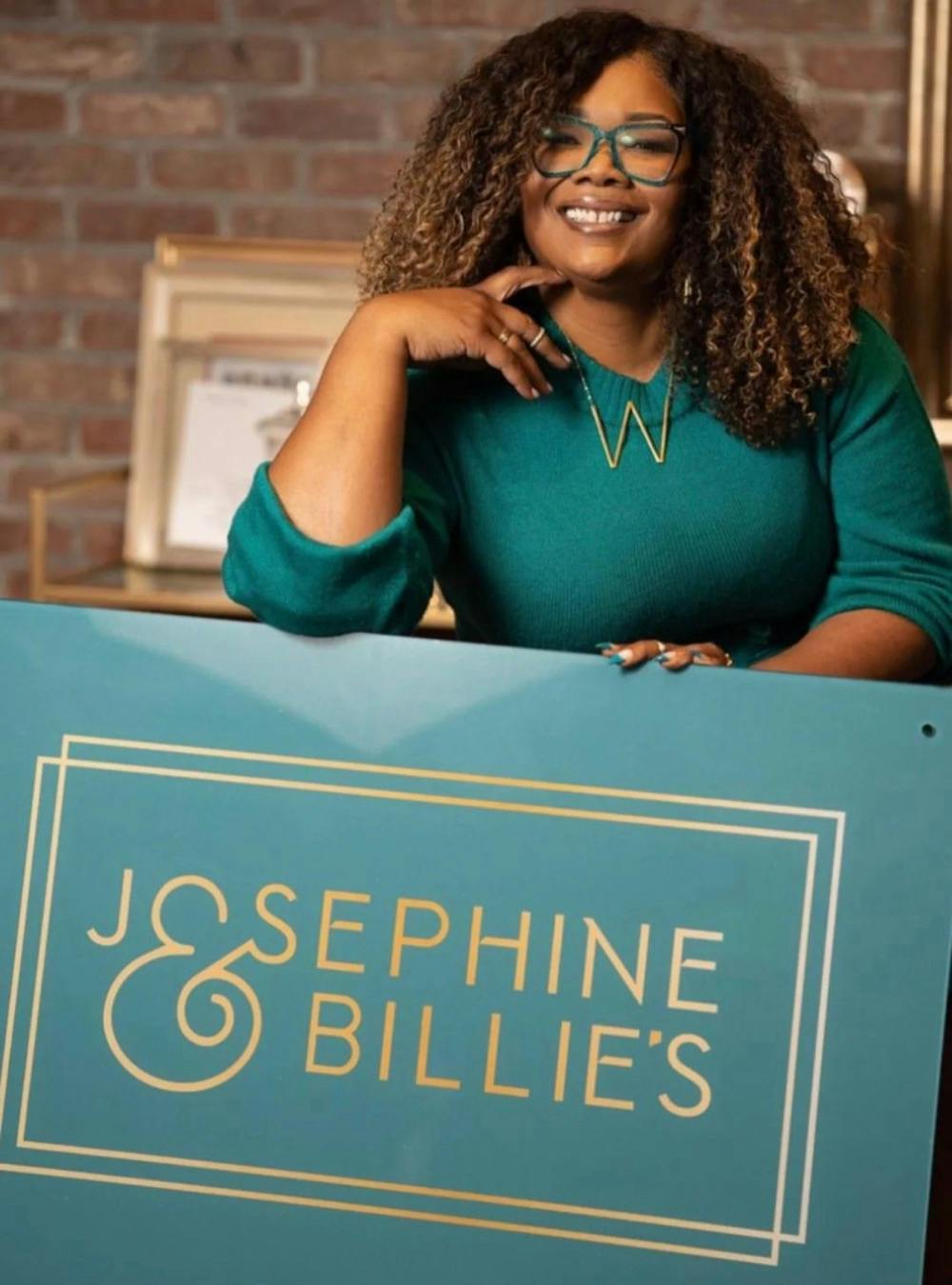 Whitney Beatty, holding sign that reads "Josephine & Billie's".