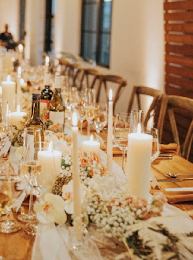 Candle lit reception table with table runner and florals.