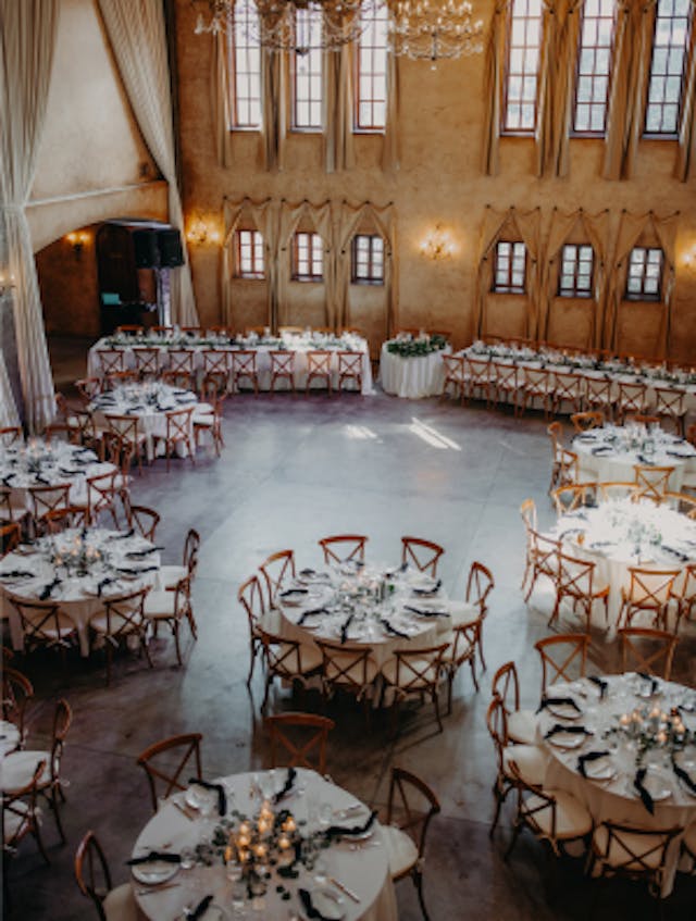 Overhead shot of reception depicting round tables, dance floor, two rectangle tables, and a round sweetheart table.