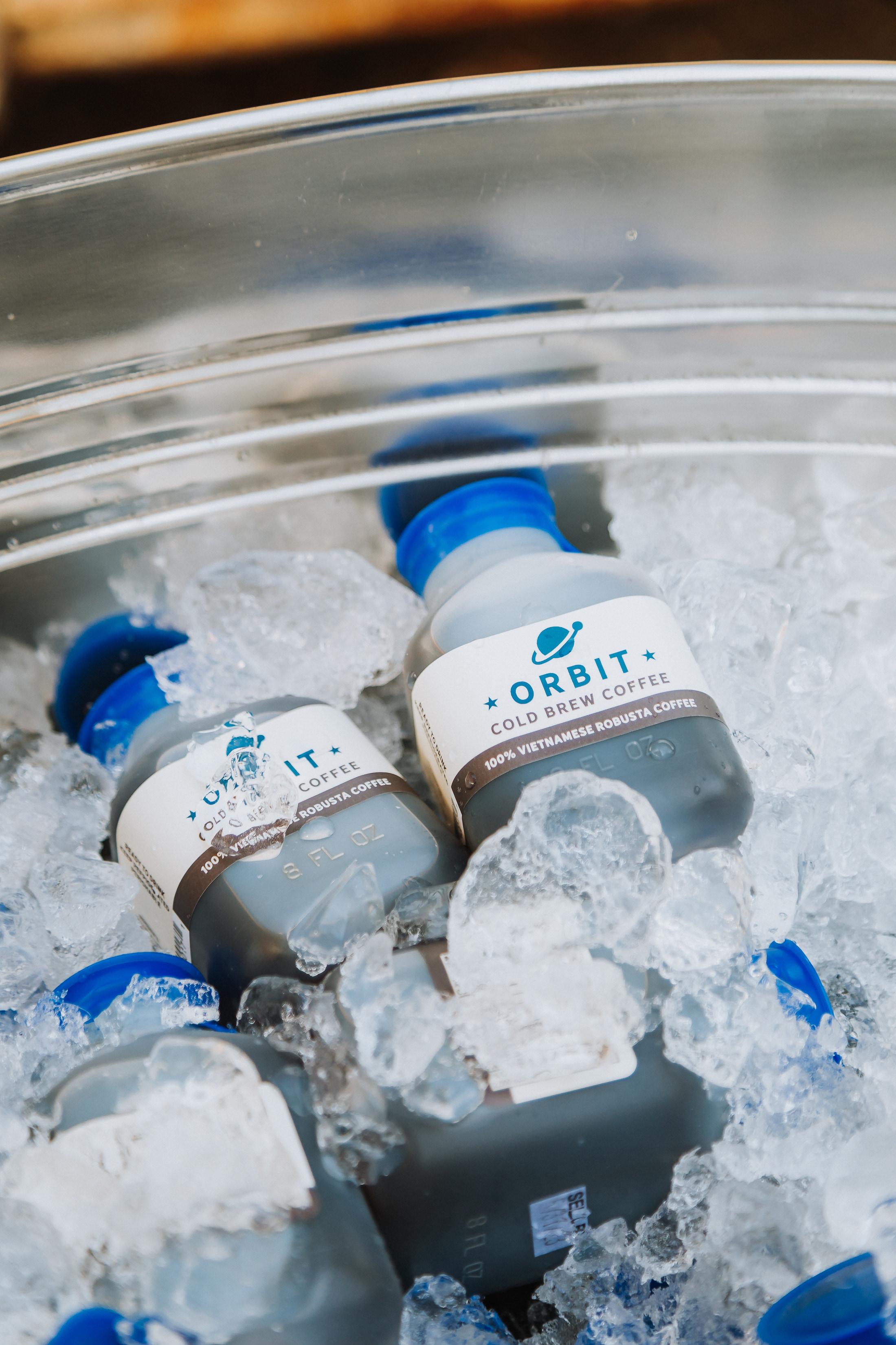 Close-up of Orbit cold brew coffee bottles in a metal bucket of ice.