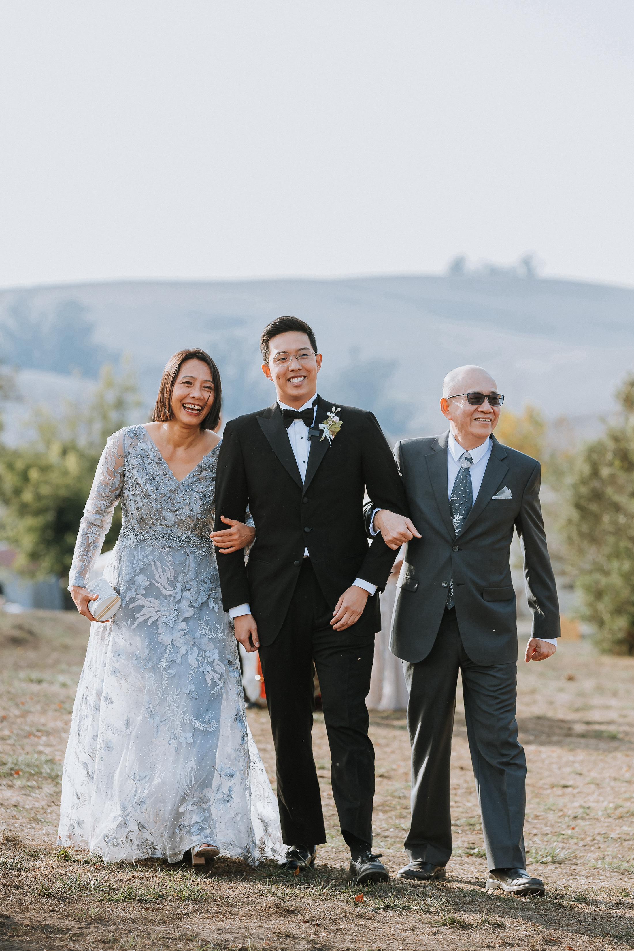 Mother and father of the groom walking the groom down the aisle.
