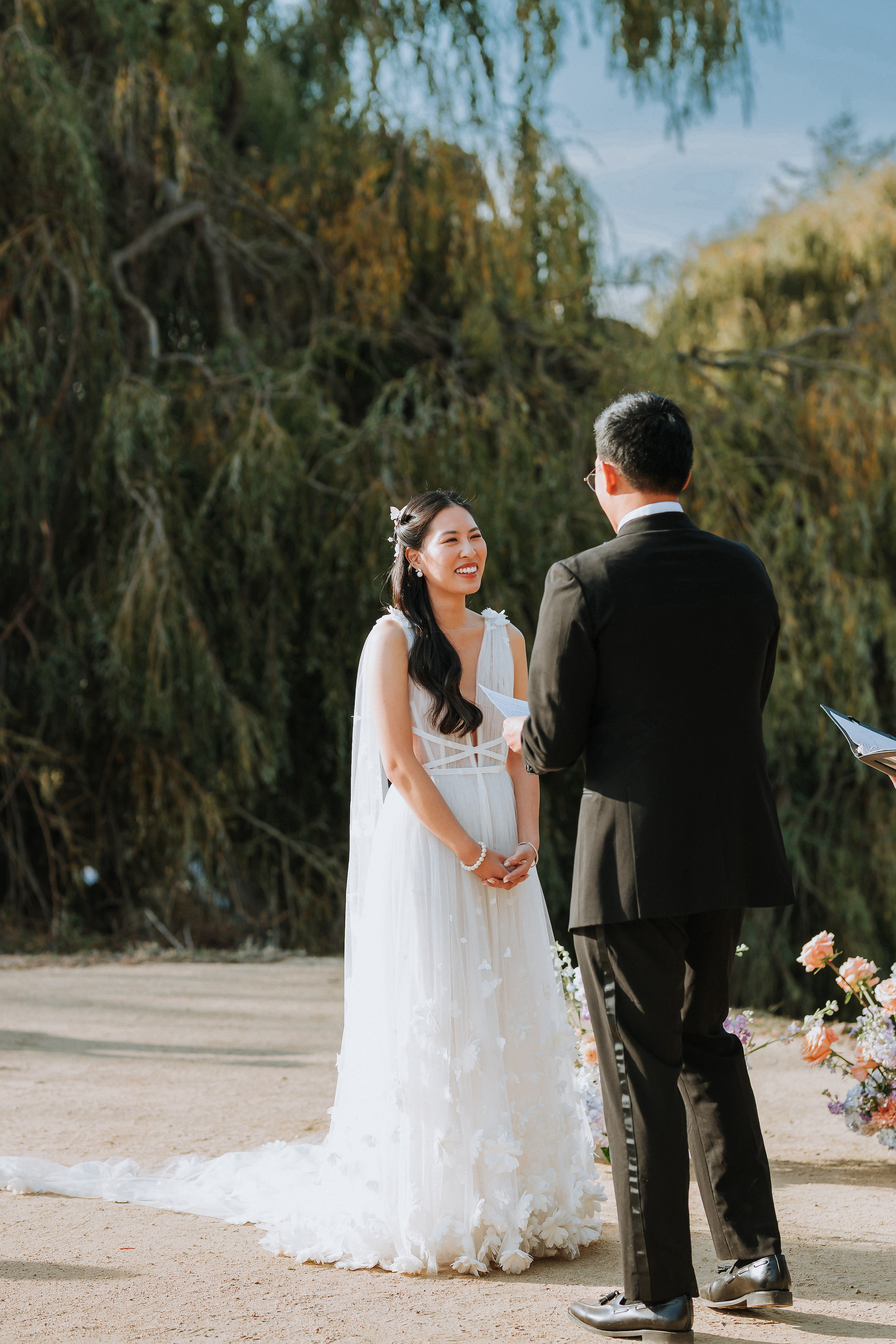 Bride smiling at groom at the alter.