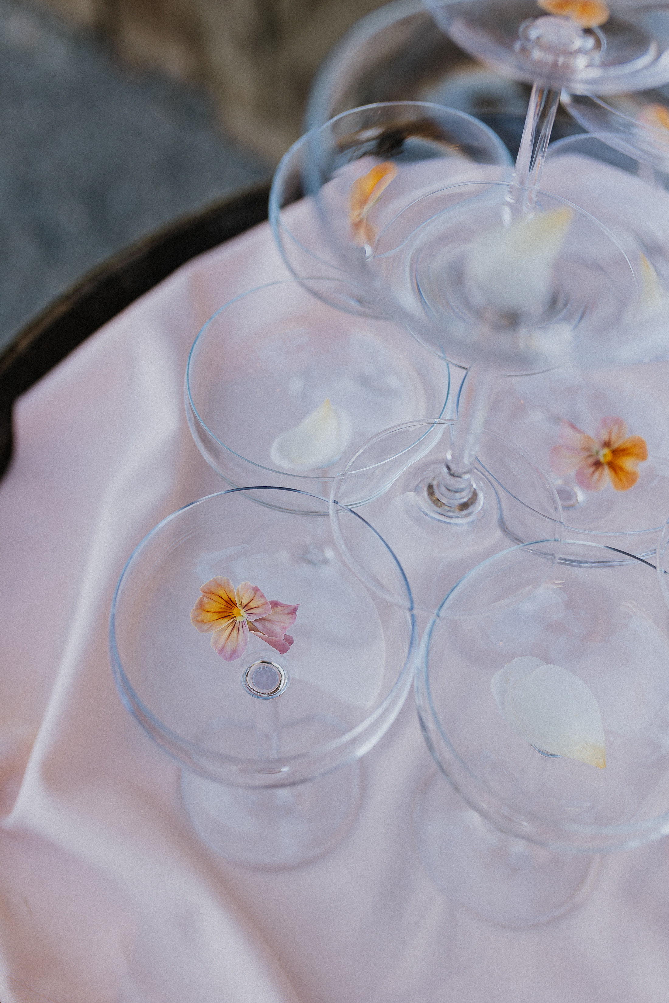 Close-up of champagne tower with decorative flowers in each glass.