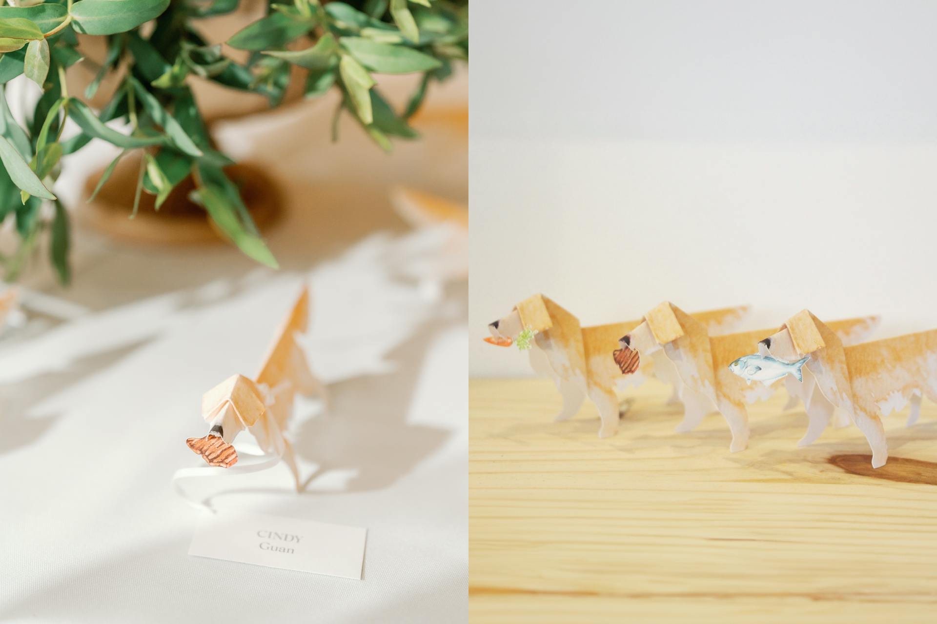 Two Images. The first image is of an origami dog meal indicator with a small paper steak in it's mouth. The second image is three origami dog meal indicators holding a paper carrot, steak, and fish in their mouths.