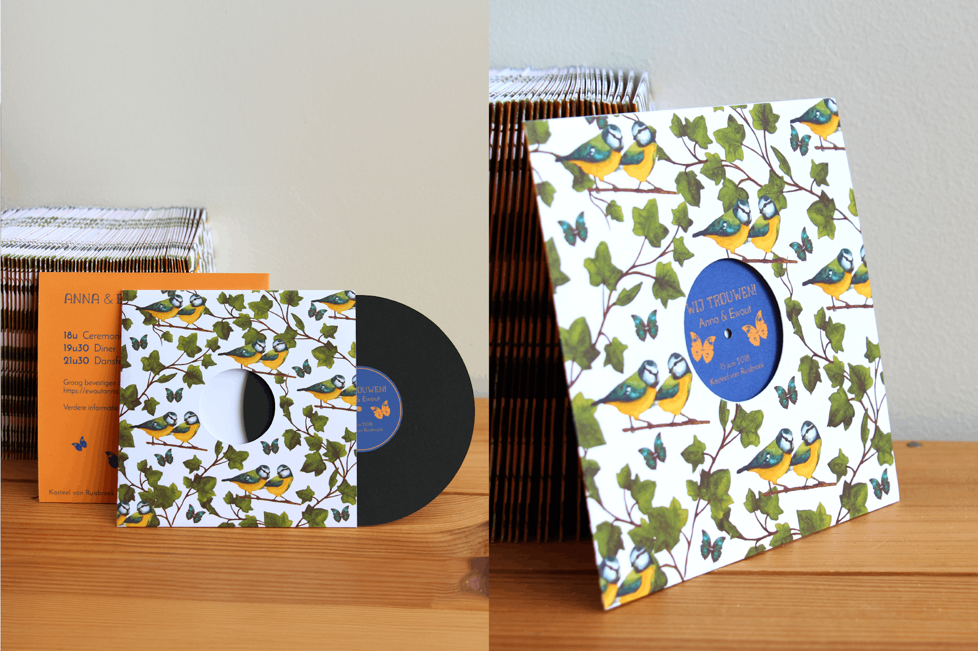 Two images. The first image is a paper invitation suite that resembles a black and blue vinyl with orange butterflies in the center in a bird-patterned sleeve. The second image is a close up of the vinyl-themed invites.