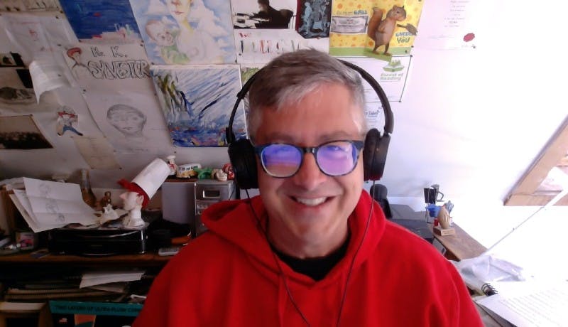 Kevin Sylvester with some of his artwork on the wall behind him