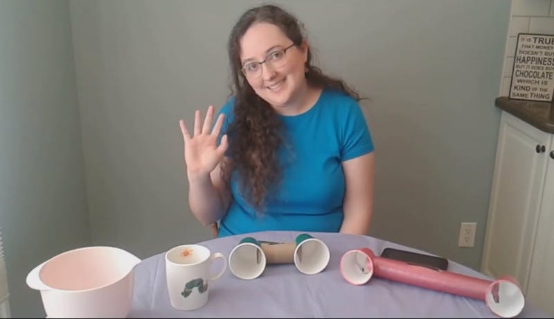 Librarian at table with amplifiers made of paper cups and rolls