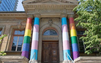 Toronto Public Library’s Yorkville Branch with transgender and rainbow flags wrapped on the pillars.