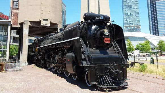 A large black train on display outside Toronto Railway Museum.