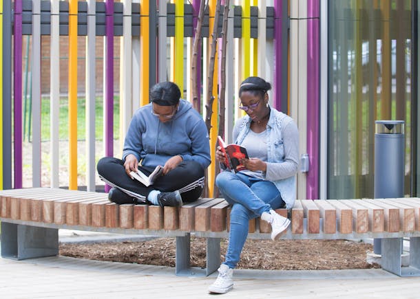 two people reading outside the library