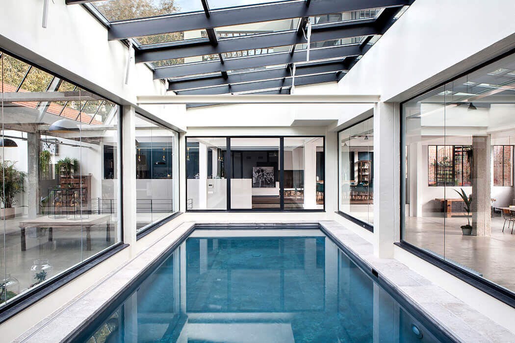 piscine intérieure de luxe baignée de lumière au centre de cette prestigieuse demeure