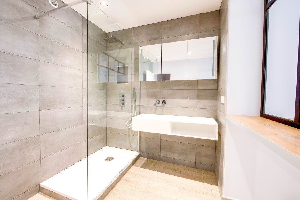 Salle de bain aux tons naturels, avec douche à l'italienne et lavabo