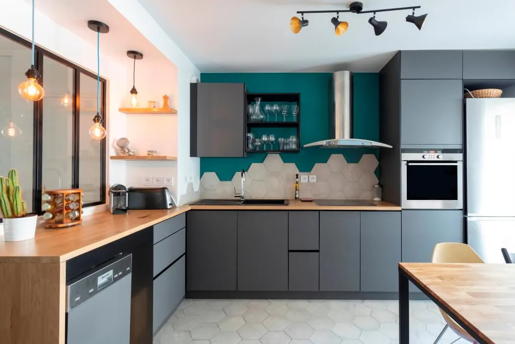 Installation de meubles de cuisine haut de gamme gris surmontés d'un plan de travail en bois massif