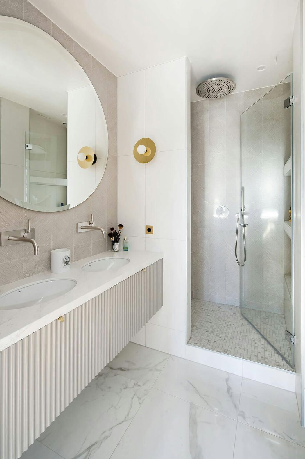 salle de bain de luxe avec double vasque, marbre au sol, et douche à l'italienne avec sol mosaïques