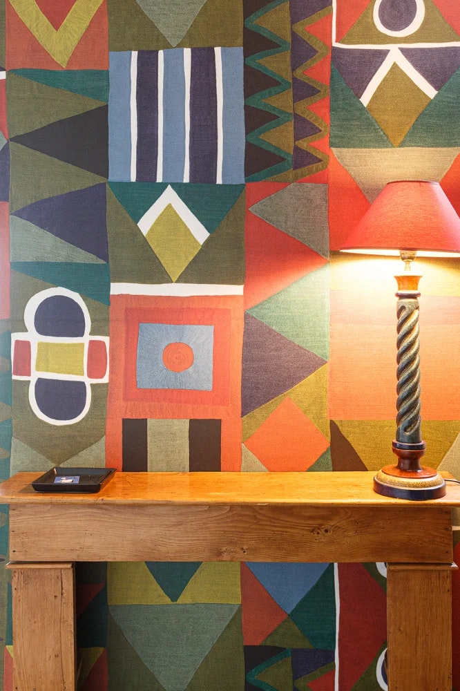 Mur multicolore, meuble en bois et lampe de table