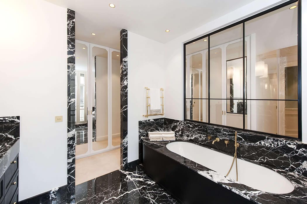 baignoire avec robinetterie de luxe et verrière pour cette salle de bain