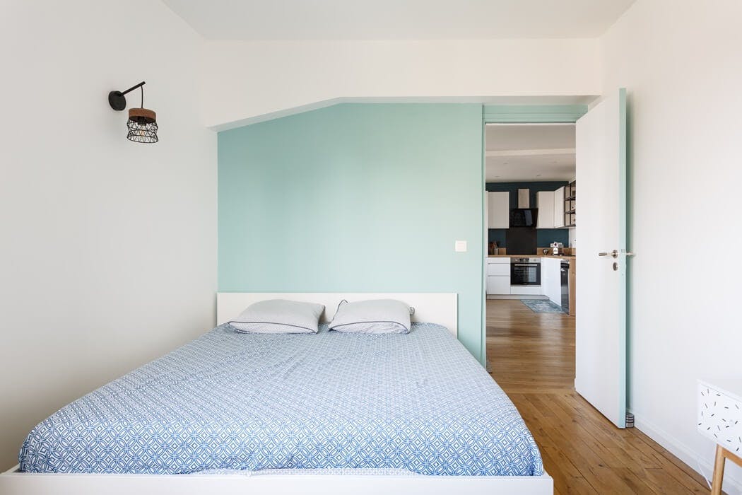 chambre parentale avec un mur vert pastel pour créer une ambiance apaisante