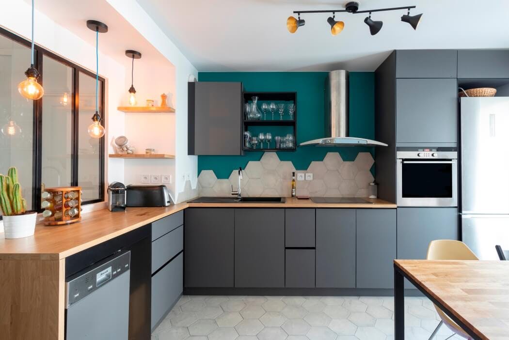 Installation de meubles de cuisine haut de gamme gris surmontés d'un plan de travail en bois massif