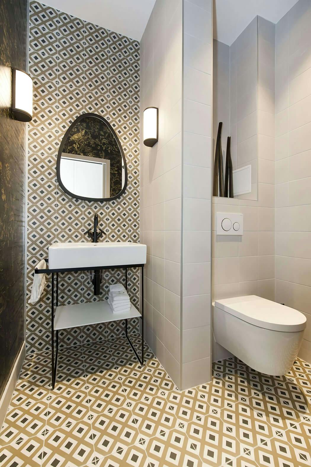 salle de bain haut de gamme très tendance avec carreaux de ciment, appliques murales et wc suspendus