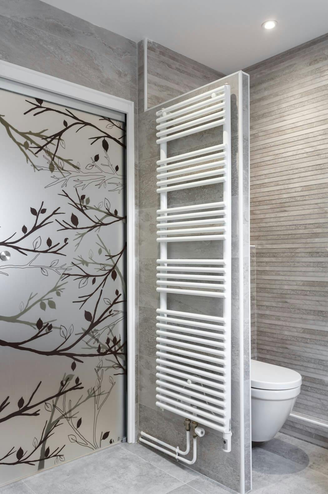 WC suspendu et sèche serviette haut de gamme dans cette salle de bain rénovée aux tons gris