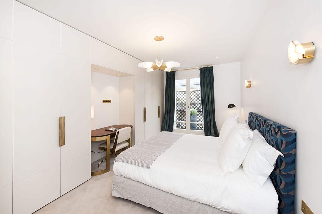 chambre parentale à la déco raffinée avec dressing sur-mesure, tête de lit personnalisée et lampes design