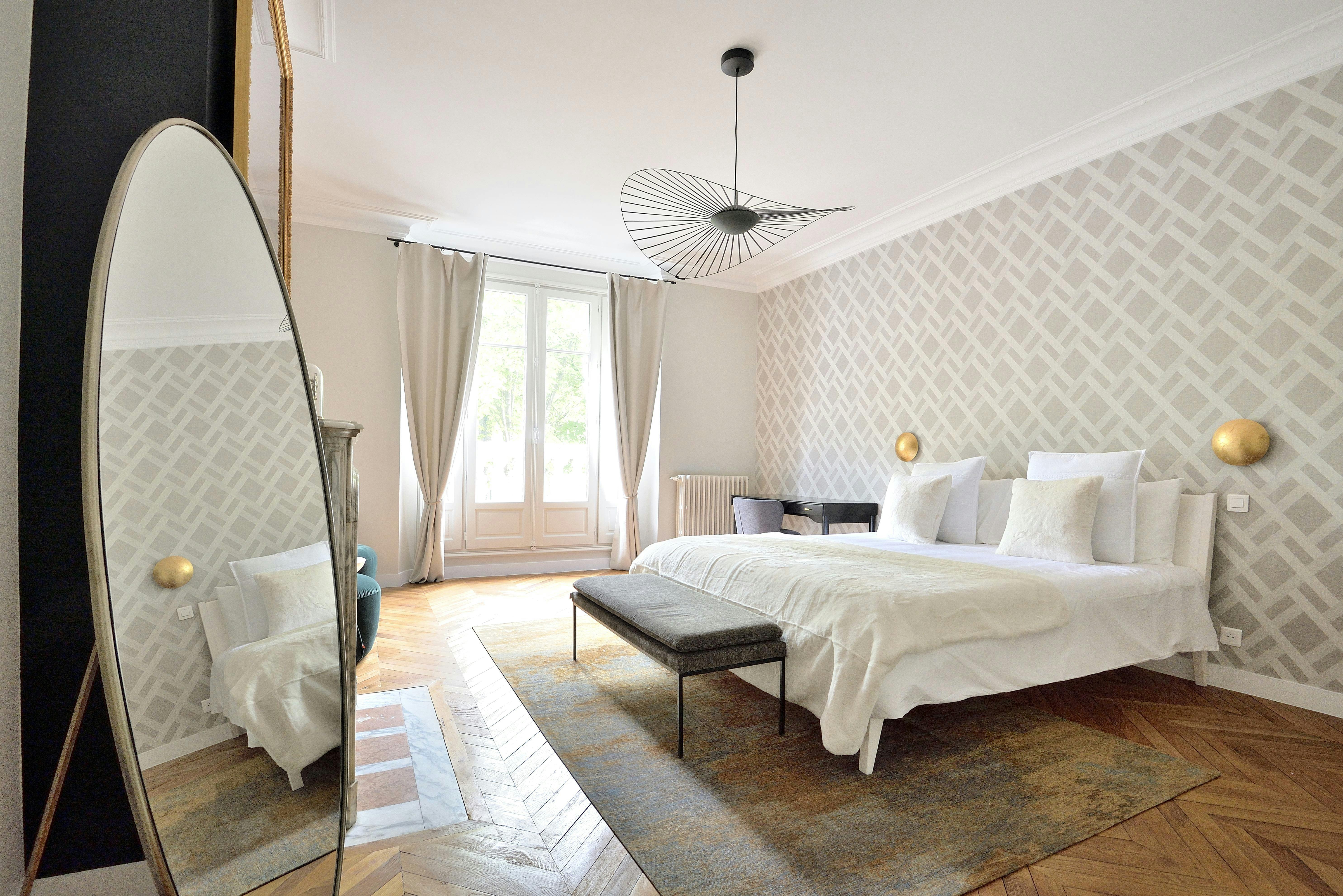 Une chambre élégante avec papier peint graphique et lumière naturelle.
