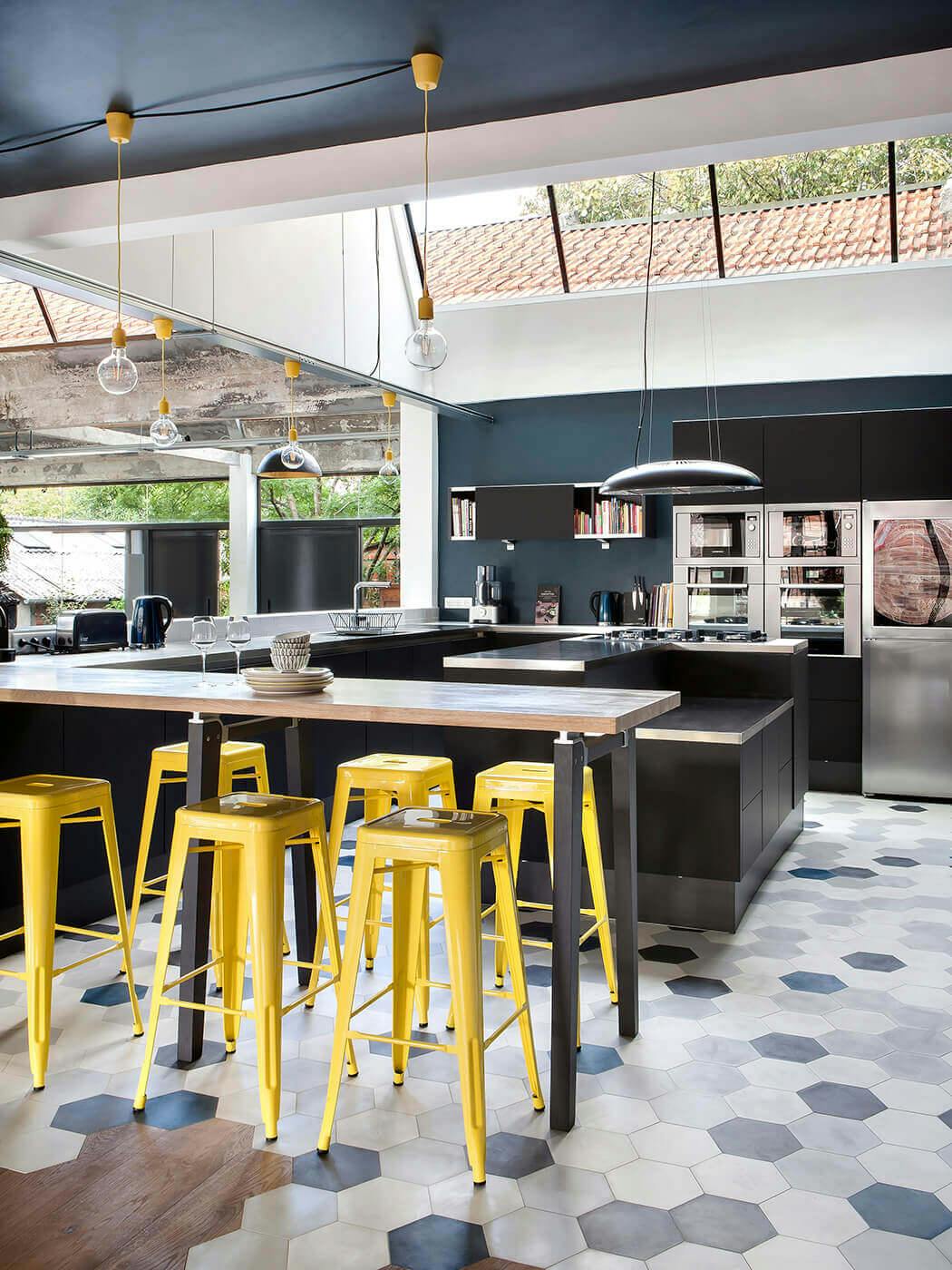 Dans la cuisine luxueuse de ce loft, les éléments sont très épurés et le sol mêle carrelage et parquet