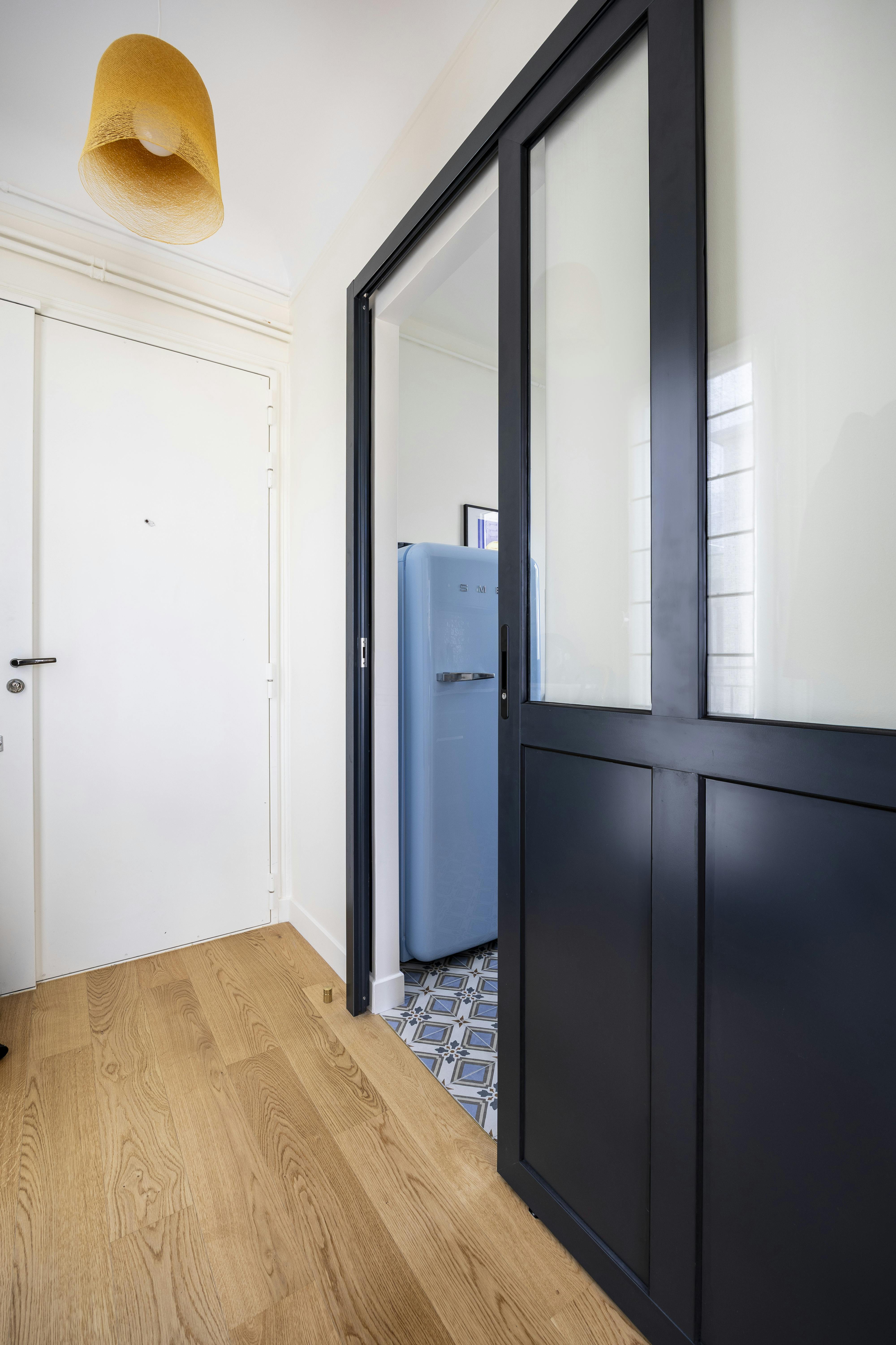 Une porte verrière bleu foncé donne du caractère à l'entrée.