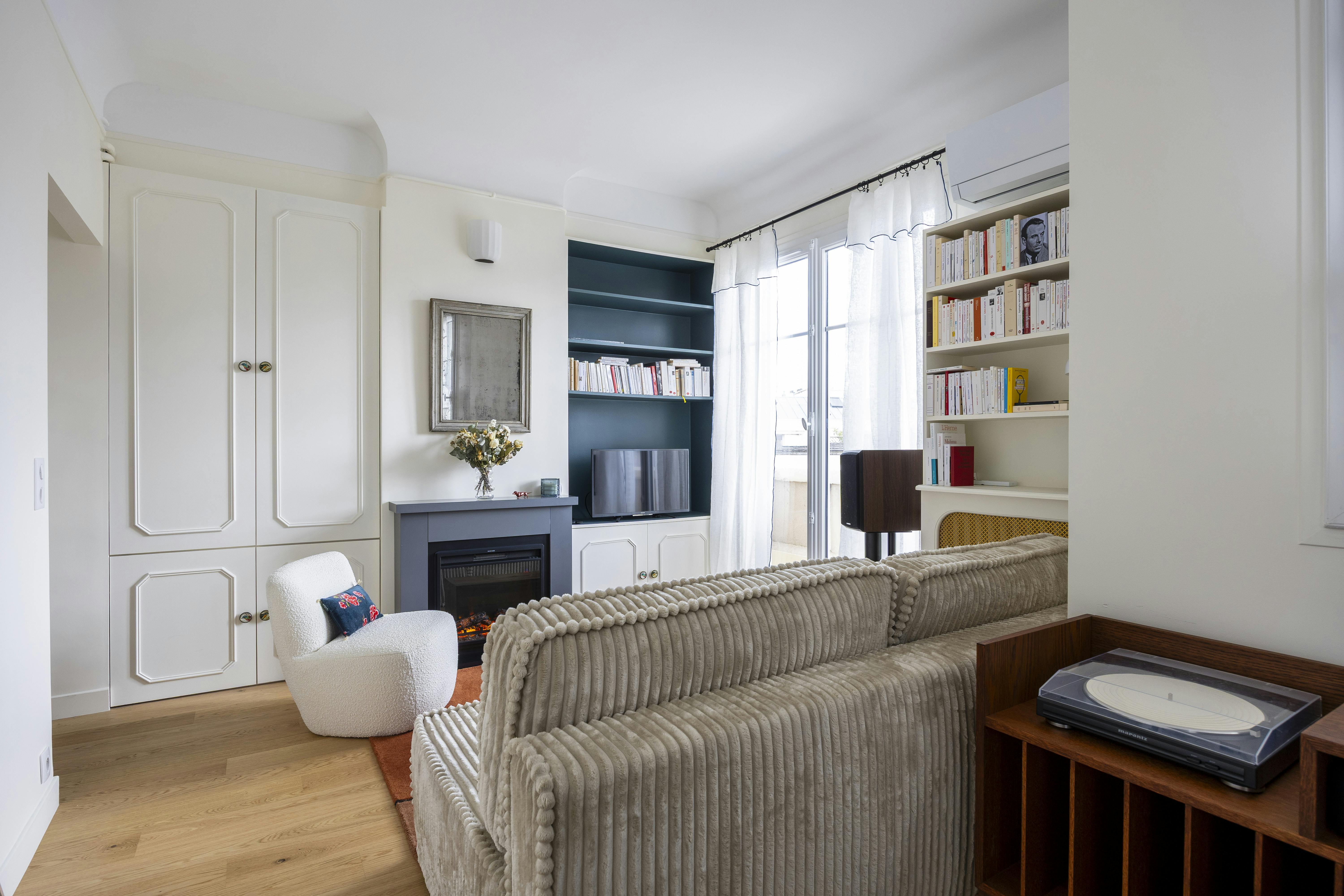 Salon chaleureux avec rangements sur-mesure et lumière naturelle.