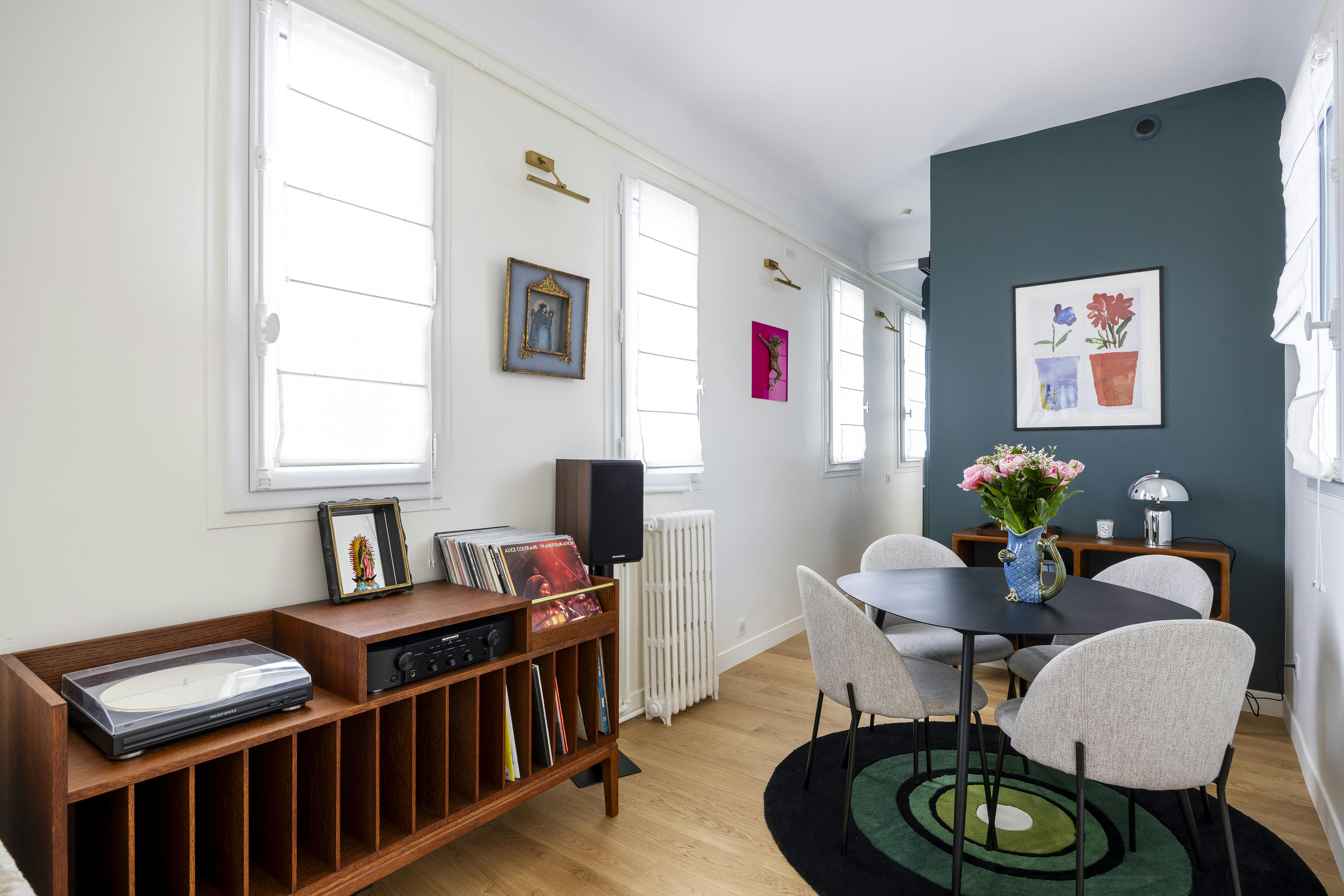 Une ambiance vintage avec un meuble vinyle et des œuvres murales.