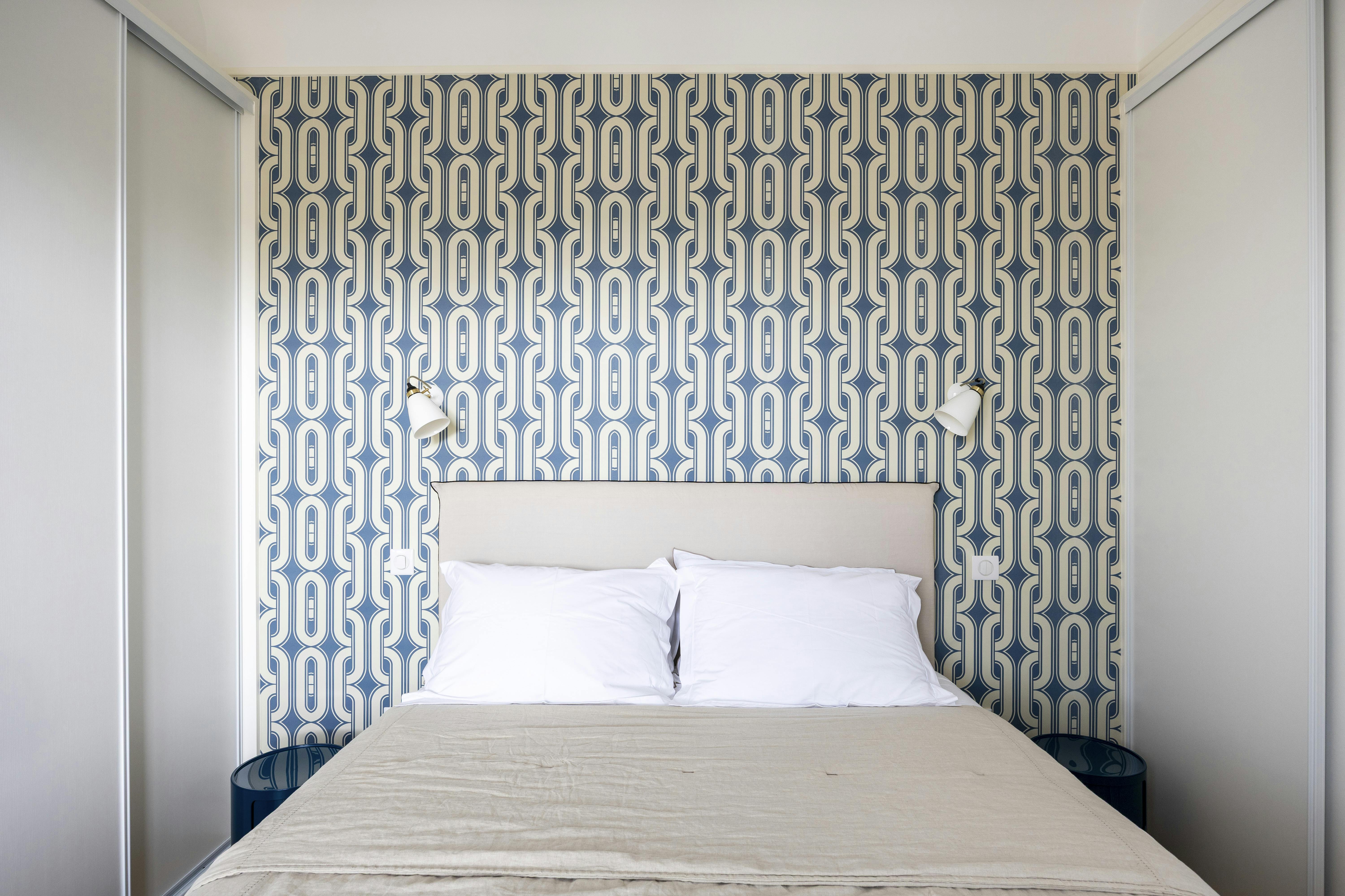 Chambre au style affirmé avec un papier peint rétro chic.
