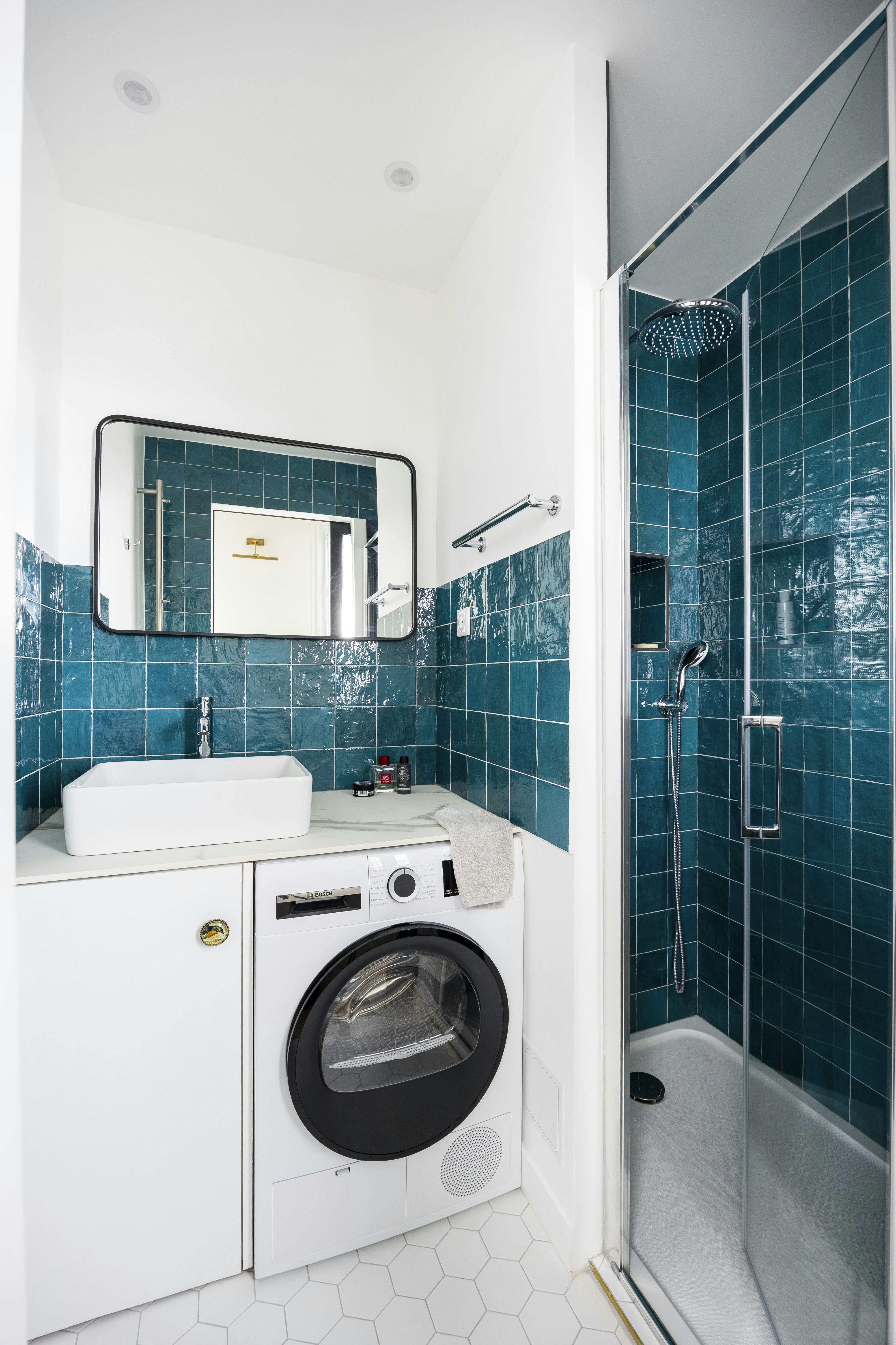 Une salle de bain sublimée par des carreaux émeraude et un aménagement optimisé.