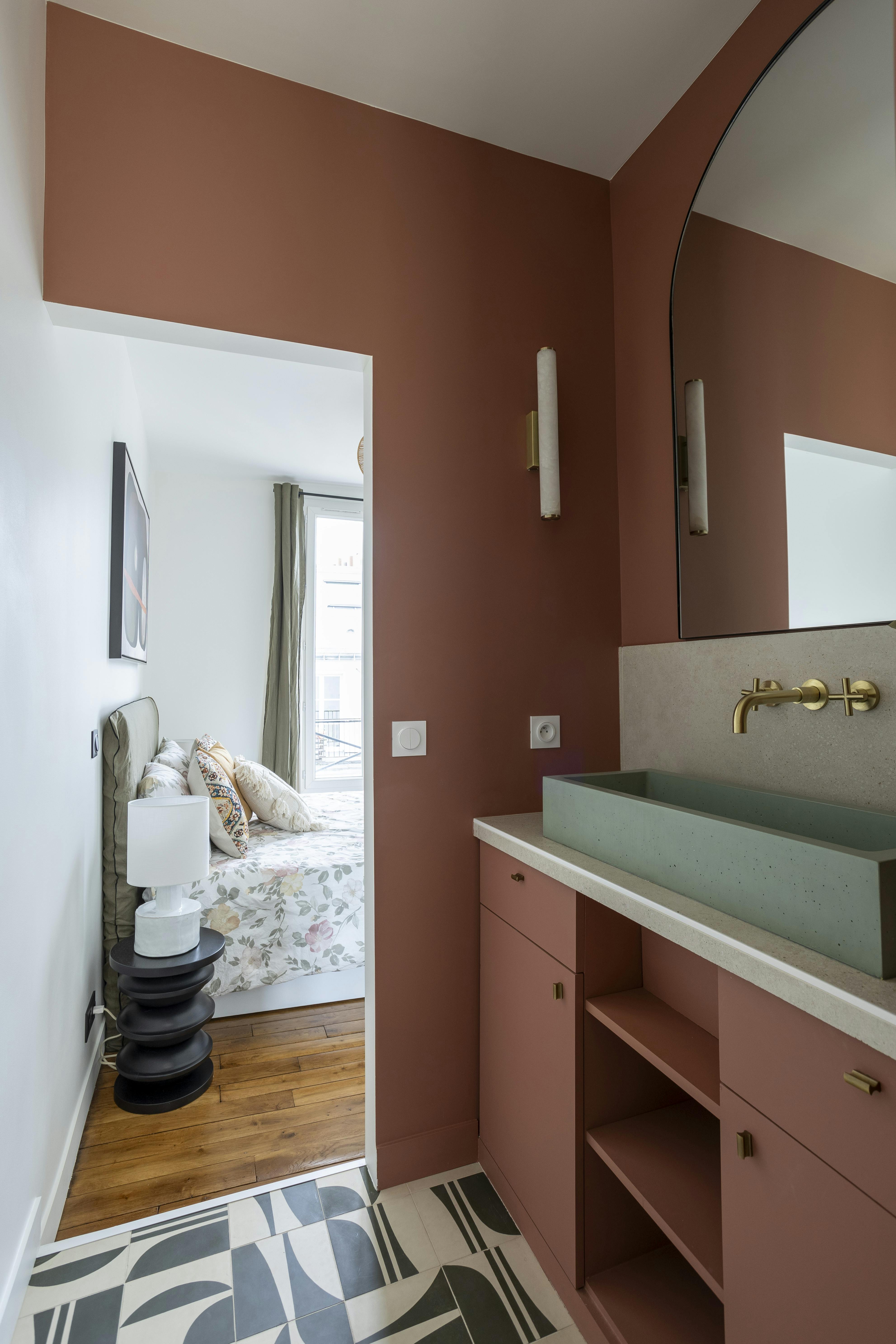 Salle de bain colorée avec vue sur la chambre.