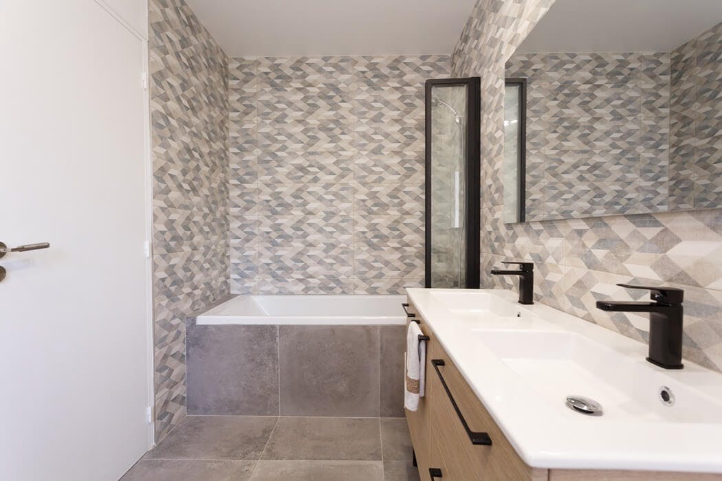 Salle de bain au style dynamisant, grâce à un carrelage mural aux motifs géométriques