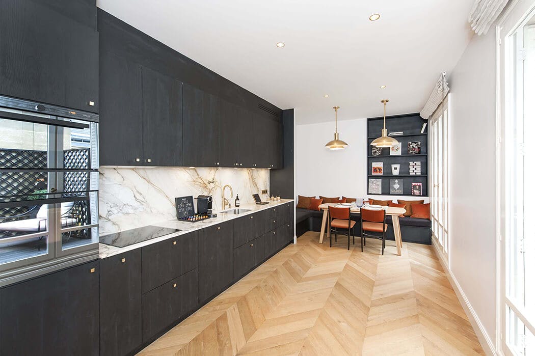 cuisine de luxe anthracite en i avec parquet à chevrons et espace repas